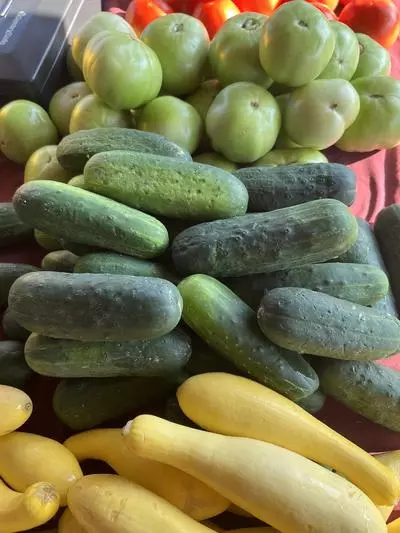 squash and cucumbers on a table at the farmers market